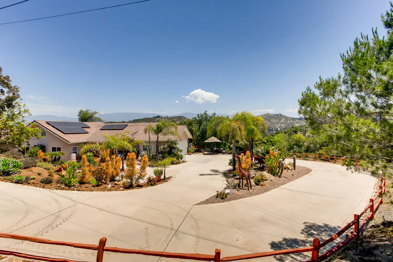 The circular drive at the front of the main house with drought-tolerant planting and palms