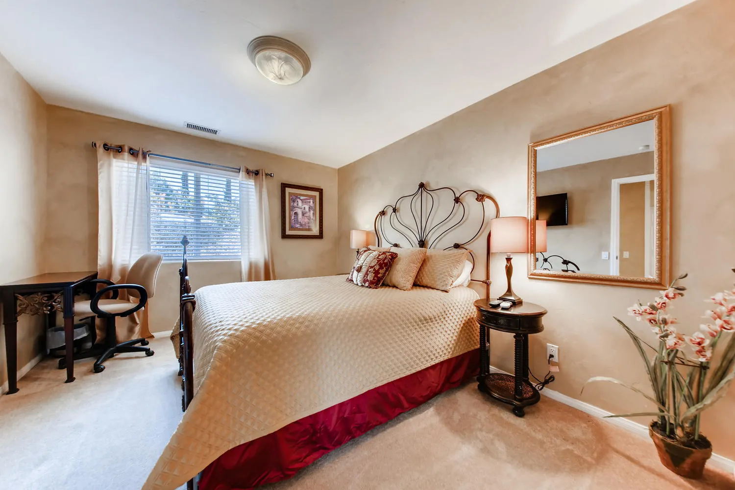 The Guest Room with a queen bed, an iron headboard and a desk under the window