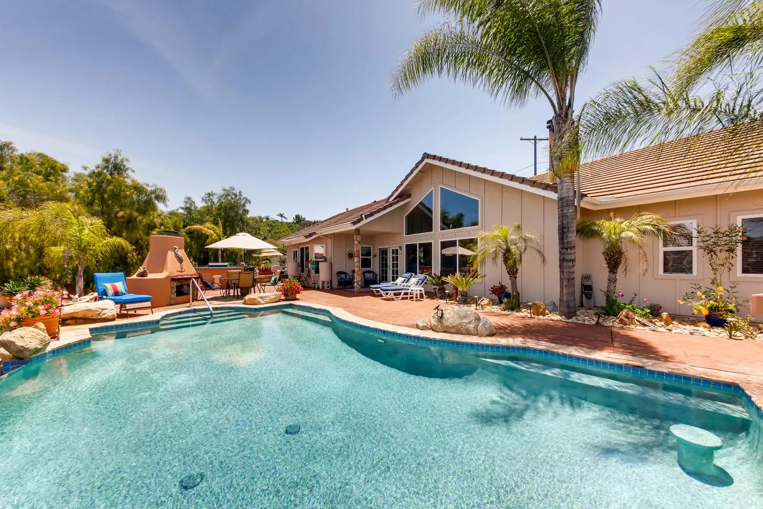 The pool deck and patio seating in front of the main house
