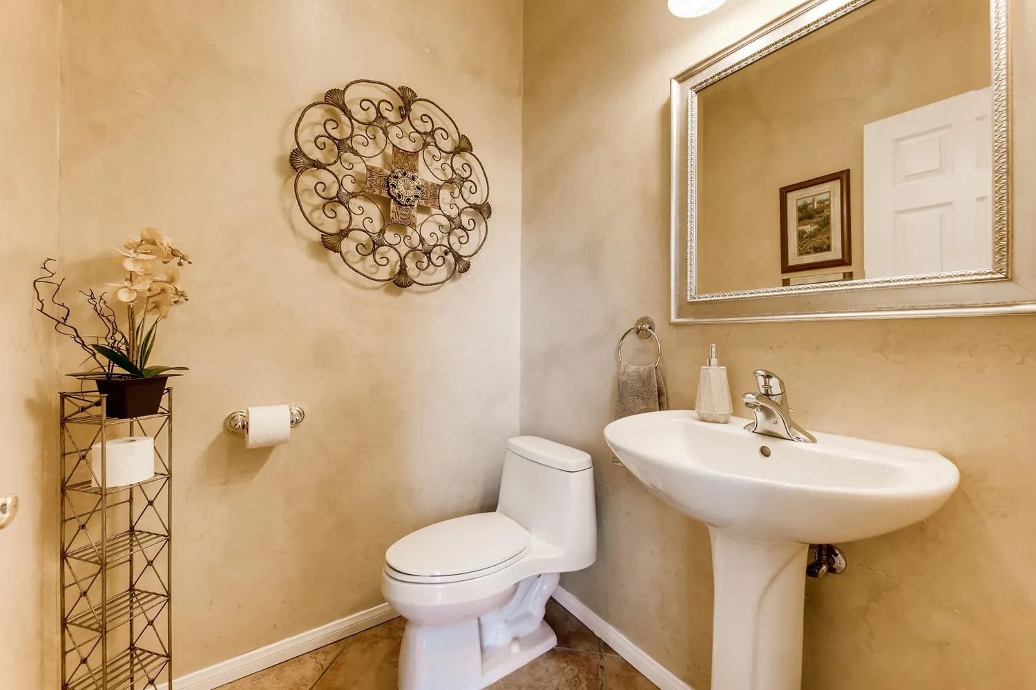 The powder room with a pedestal basin and a framed mirror